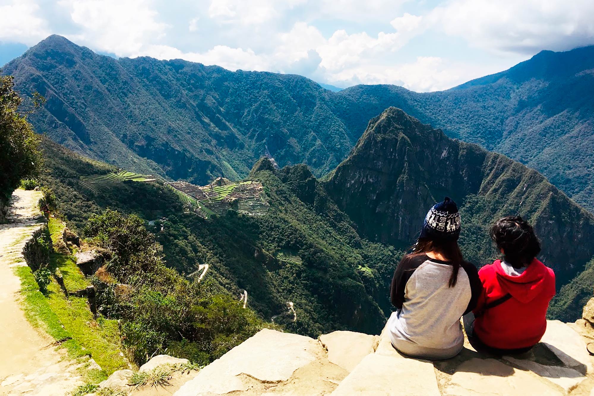 Dos viajeros contemplan Machu Picchu desde un mirador del Camino Inca