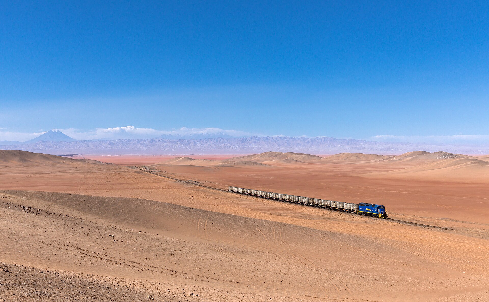 Tren turístico andino avanzando por la vía entre montañas
